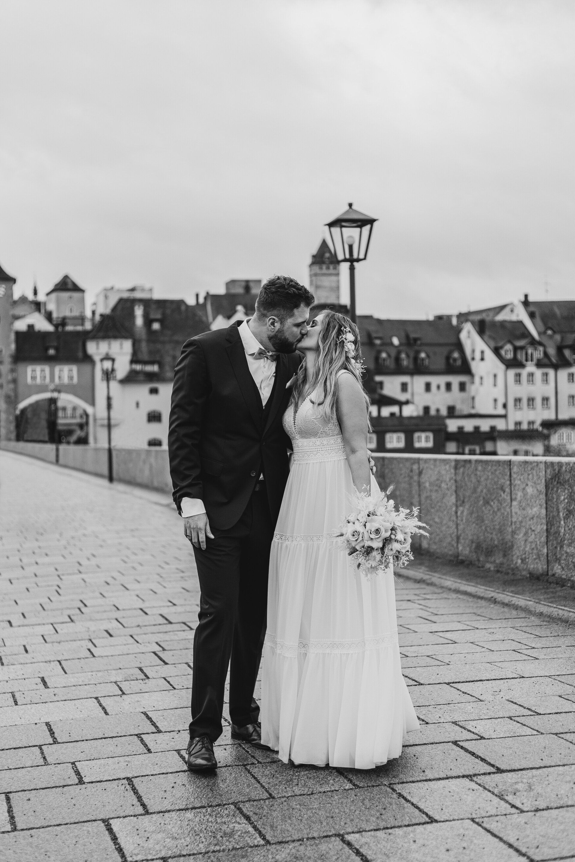 Auf dieser Aufnahme sieht man ein Ehepaar auf der Brücke in Regensburg