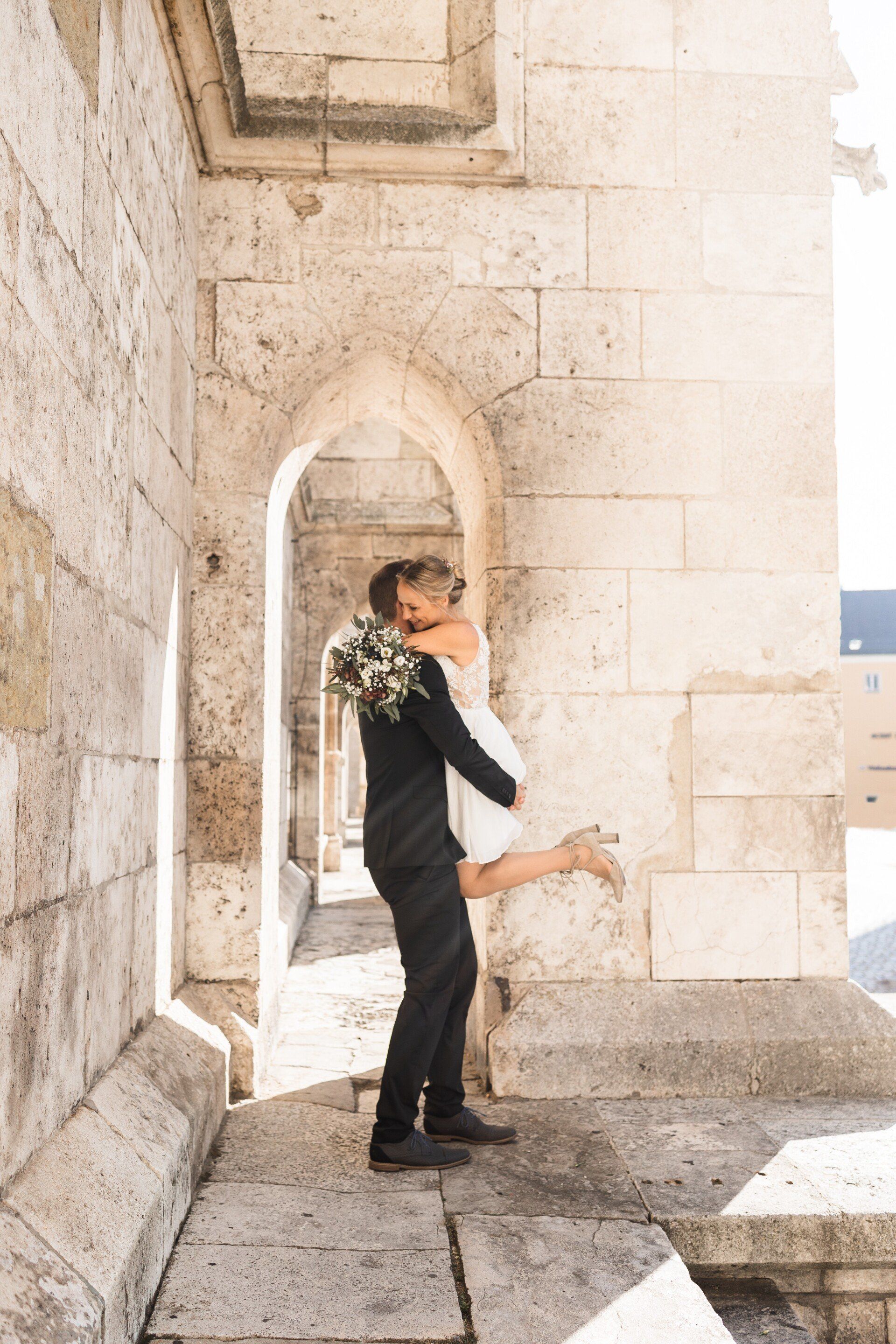 Auf diesem Bild sieht man einen Mann, der seine Frau am Dom hochhebt