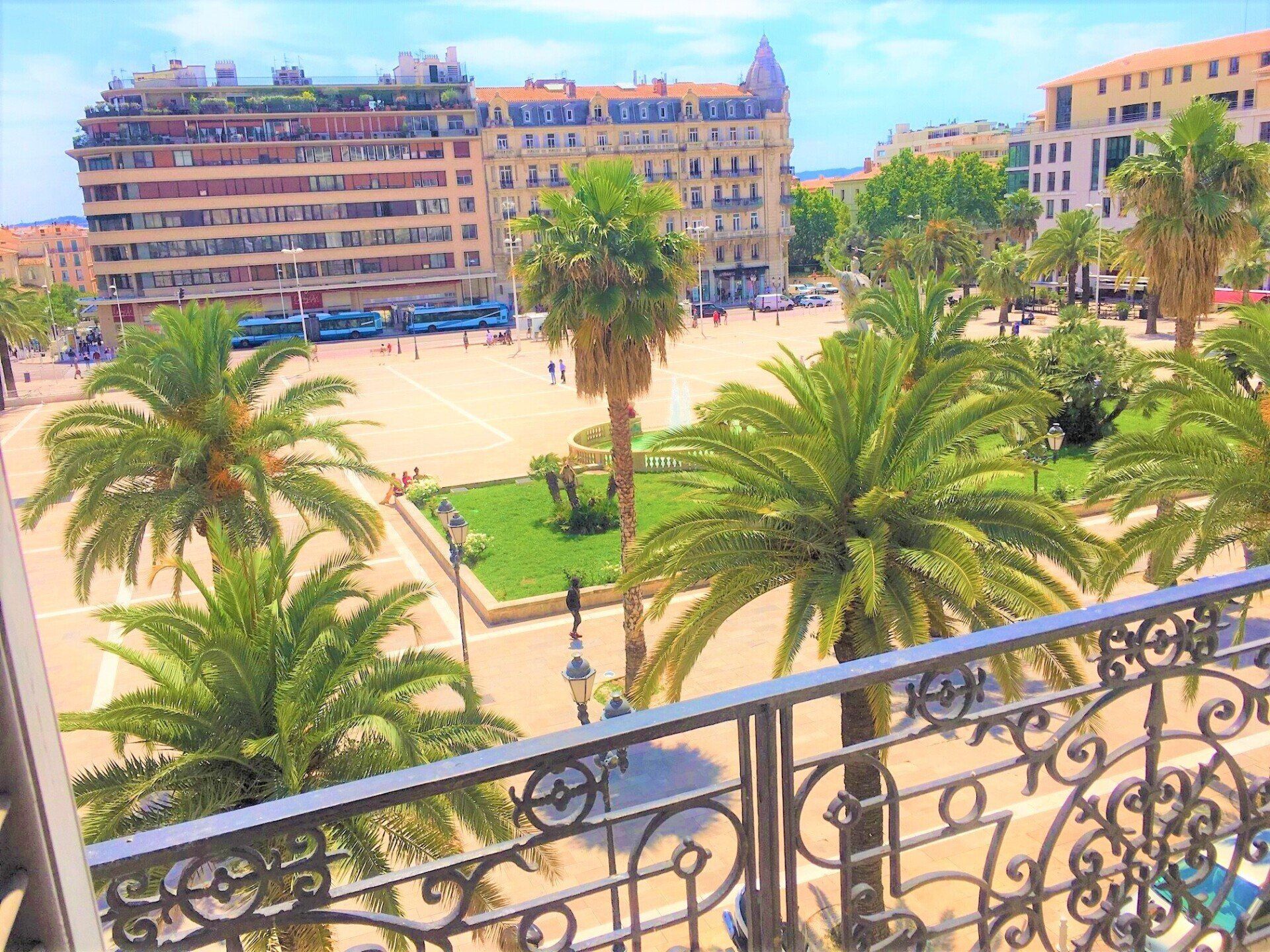 vue sur place et palmier avec balcon en fer
