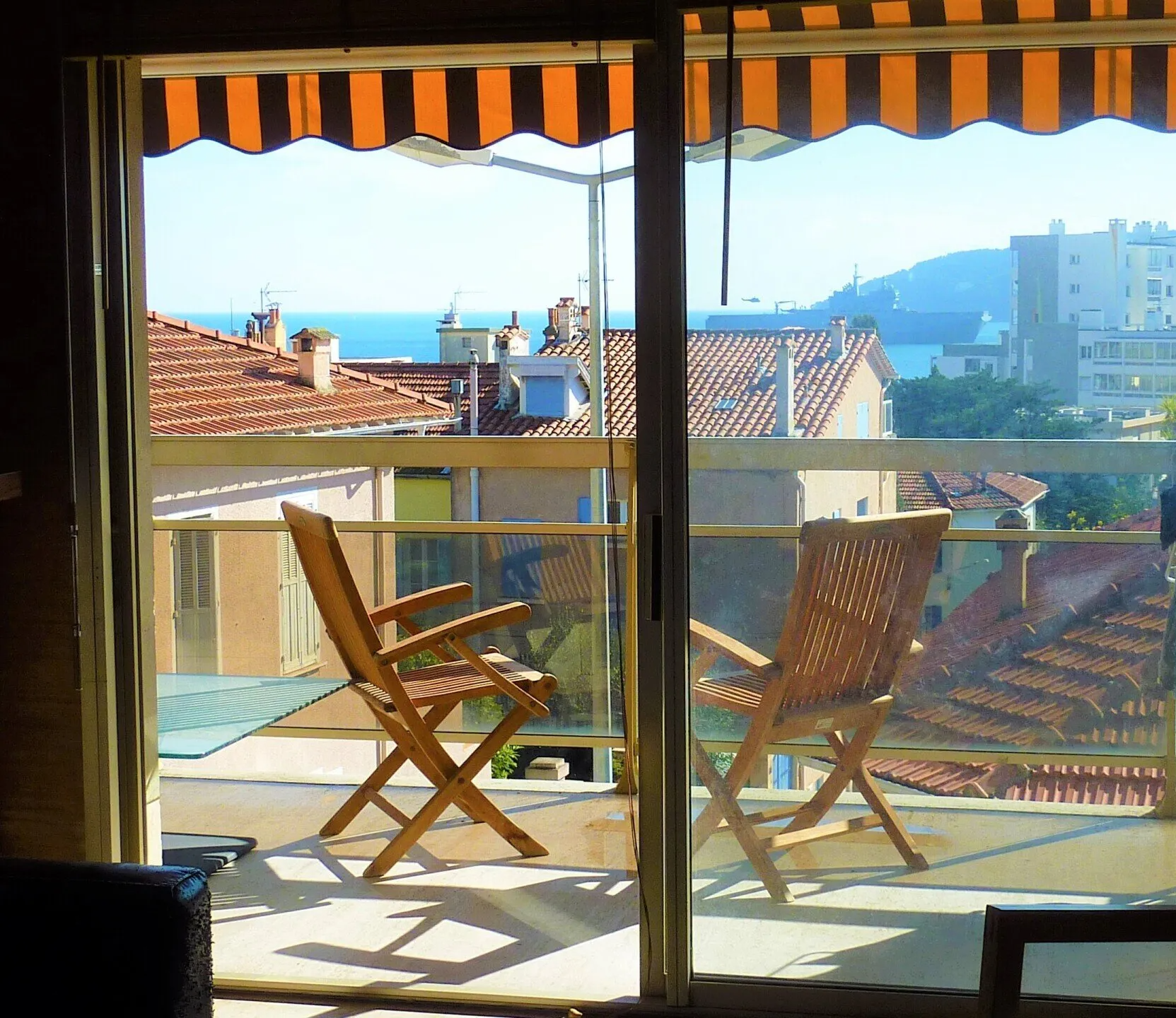terrasse avec chaise et table vue sur toits