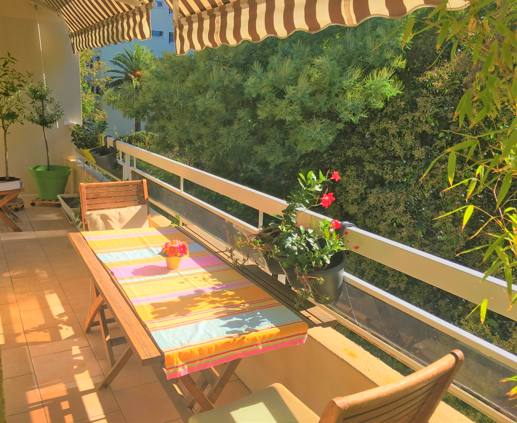 balcon avec table et store sur jardin