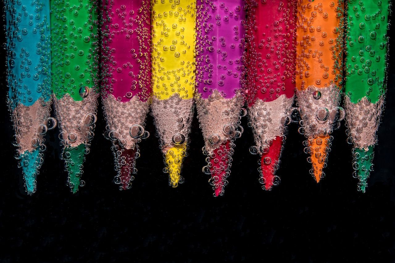 unos lápices de colores metidos en líquido