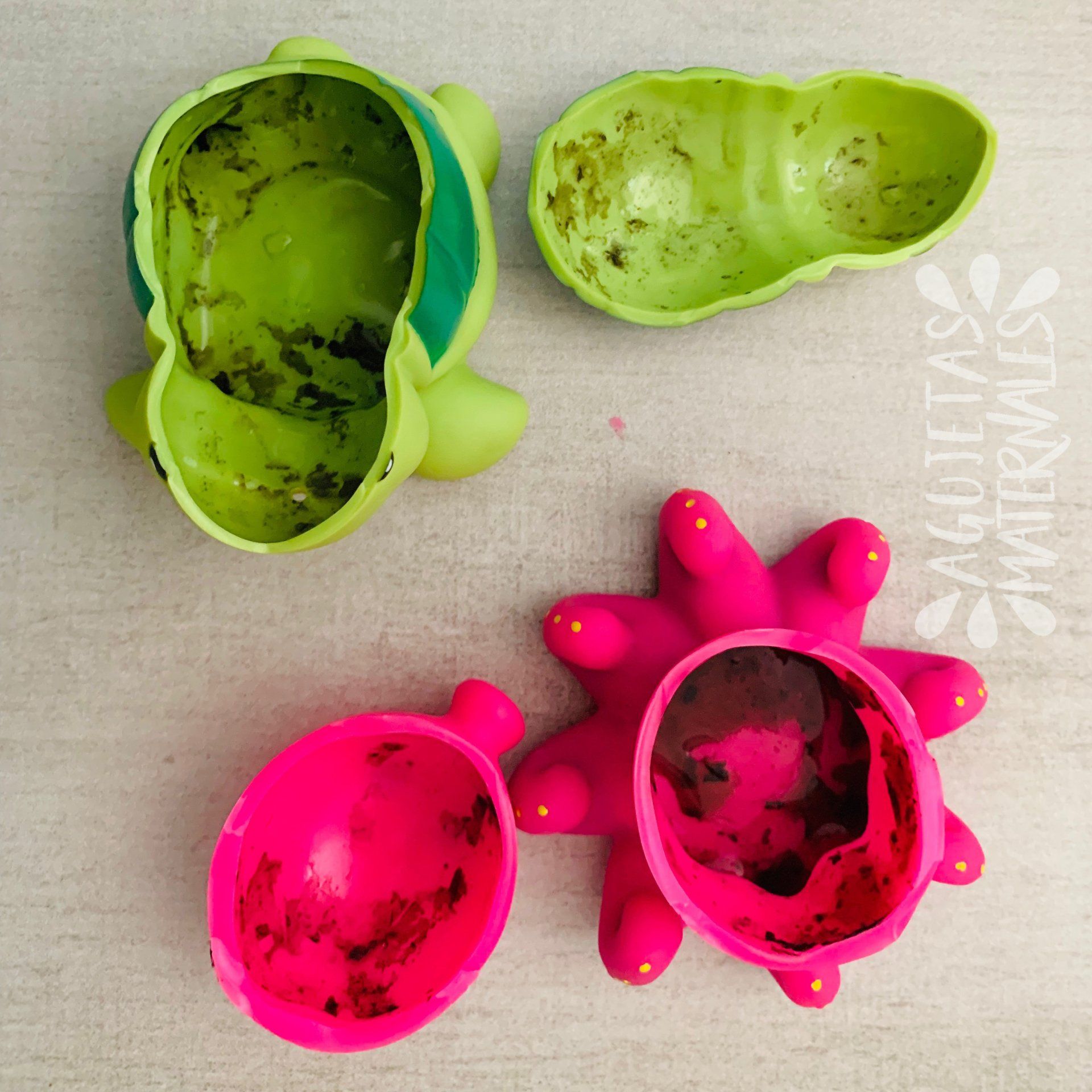 Dos juguetes de la bañera abiertos por la mitad, mostrando la suciedad que se acumula dentro.