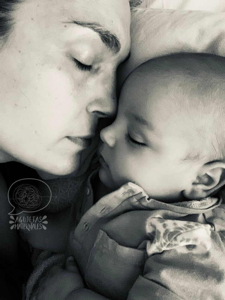 una madre joven duerme junto a su bebé