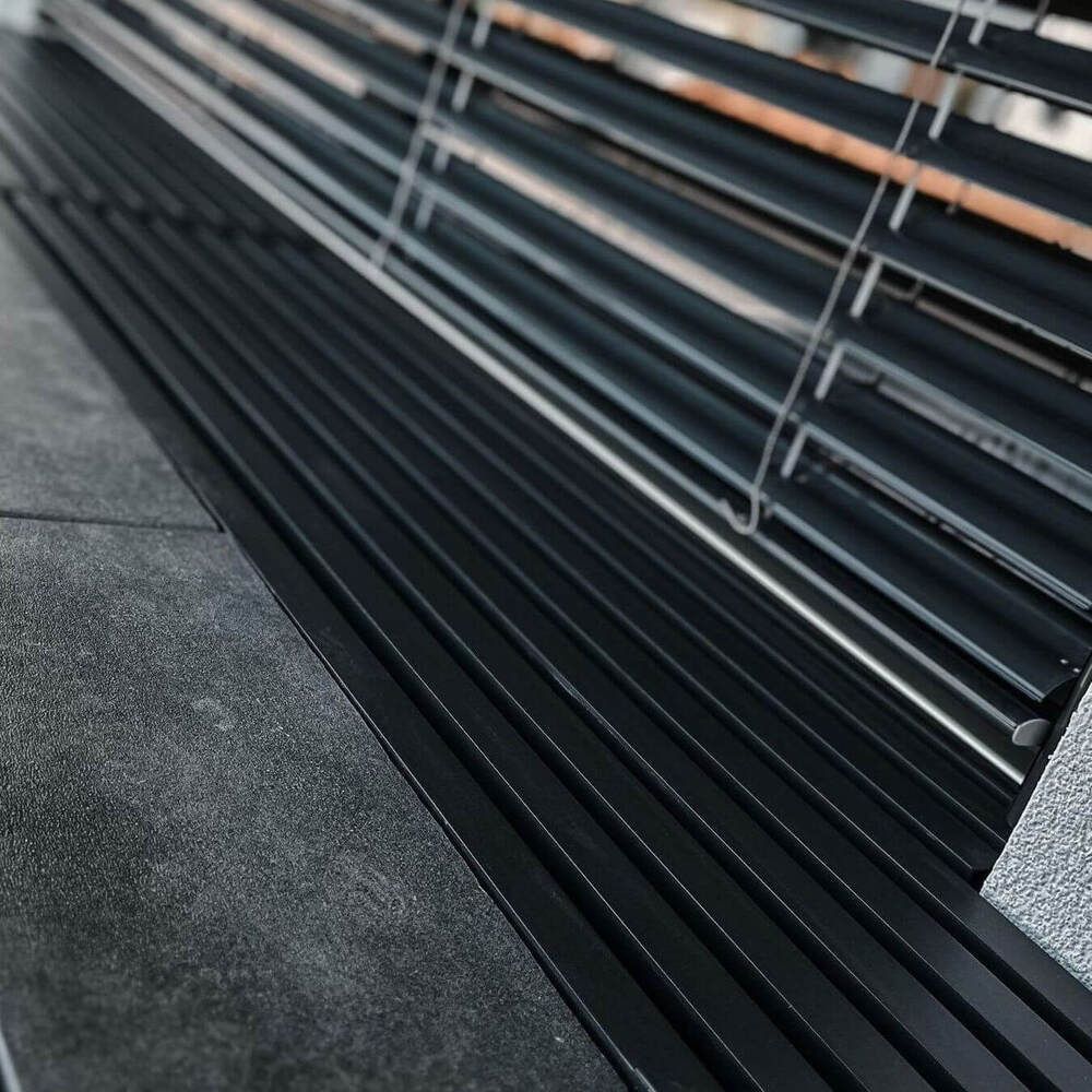 Graue Pulverbeschichtung auf einem Gitterrost an einer Terrasse im Fertighaus