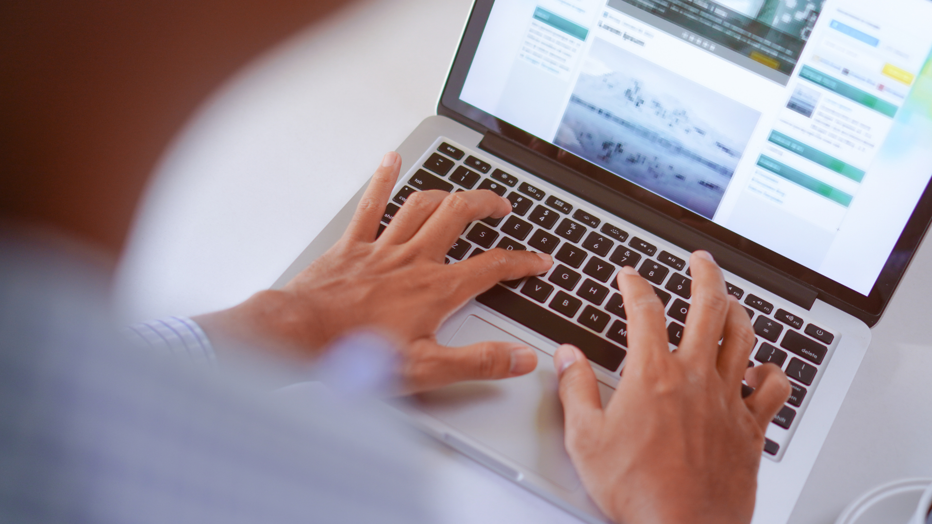 Ein Mann arbeitet an einem Laptop, auf dessen Bildschirm eine Informationswebsite mit verschiedenen Artikeln und Bildern geöffnet ist. Seine Finger befinden sich auf der Tastatur, während er konzentriert Informationen liest oder eingibt – die Szene vermittelt digitale Recherchearbeit und unternehmerische Eigeninitiative.