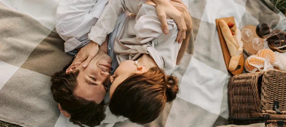 Bild mit kuschelndem Pärchen auf einer Piknikdecke