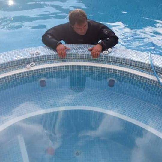 Hombre limpiando piscina sin vaciarla, Fugascaner