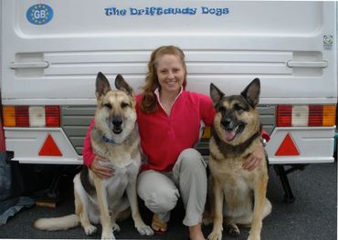 Gina, Jerry Lee, and Holly behind their caravan, The Driftaway Dogs, during their 3-year tour of the UK.