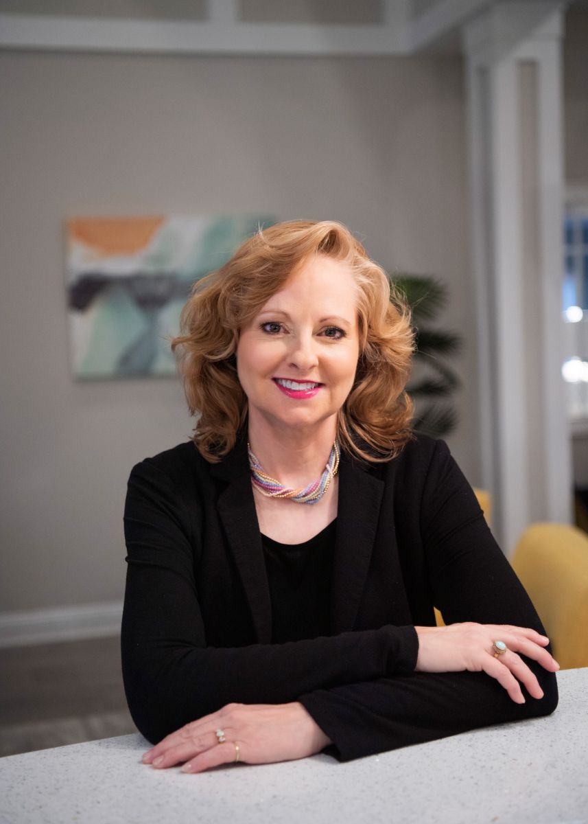Gina M. Longo sitting at a conference table.