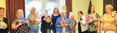 A few of the participants in the mini-workshop show their collaged clocks during Show & Tell.