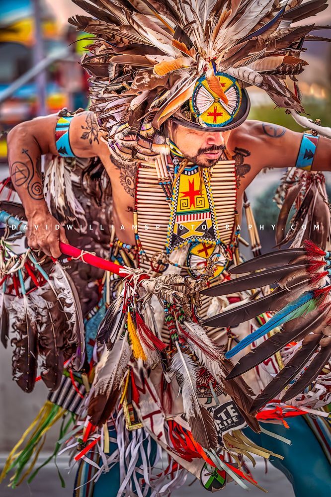 Close-up of a Hopi Indian performing a traditional war dance in colorful ornate attire, captured vertically with fine art storytelling detail.