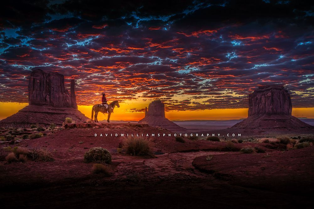 A Navajo Indian on horseback watching sunrise, Monument Valley