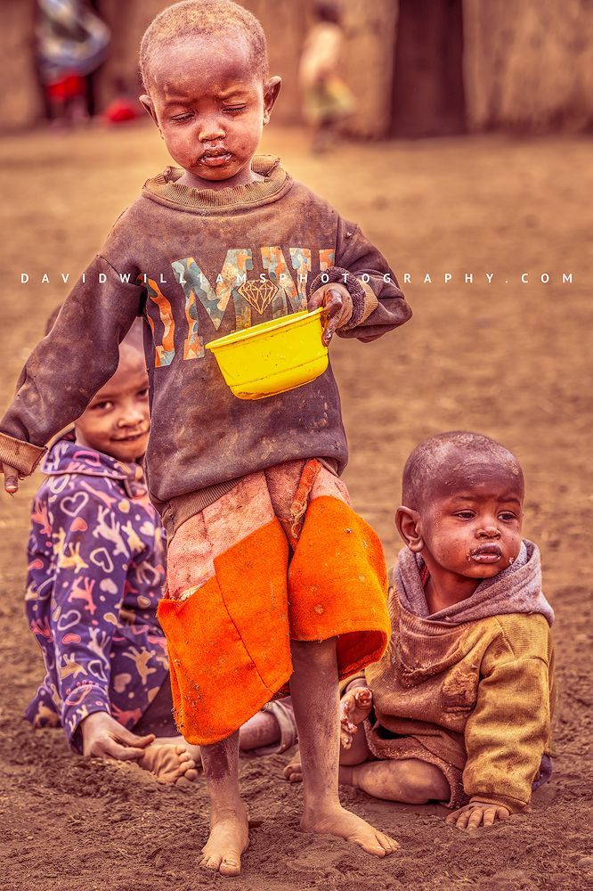 Three Maasai boys wearing worn clothing sharing a meal, Kenya 3 Maasai boys with dirty ragged clothing, Kenya