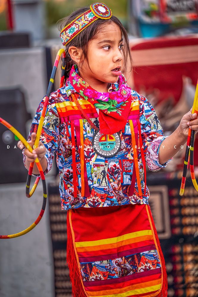 Young Navajo girl performing a traditional hoop dance, forming symbolic shapes with hoops to represent life, nature, and the circle of life