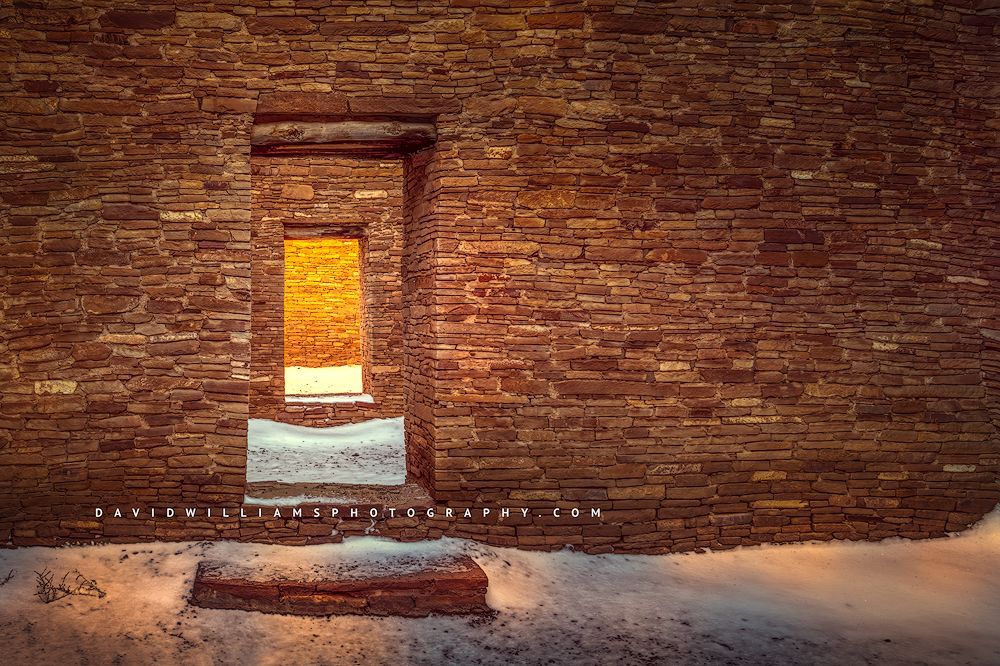 A sunlit doorway in fresh snow in Chaco Canyon New Mexico