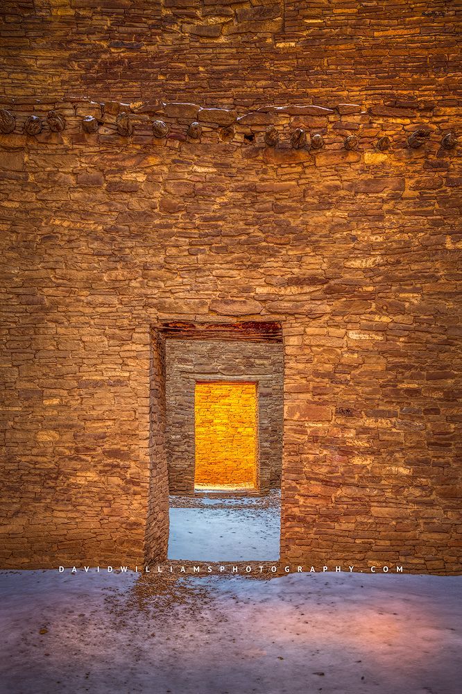 A sunlit doorway in fresh snow in Chaco Canyon New Mexico