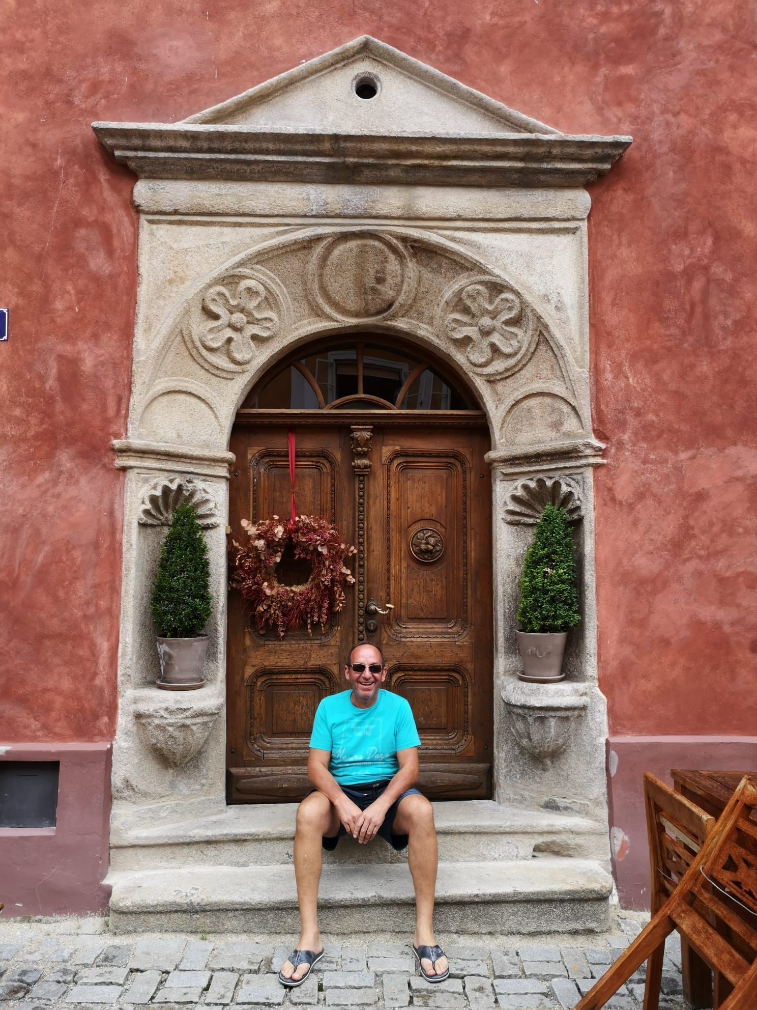 Firmengründer Reinhard Fuchs platziert sich vor einer beeindruckenden Haustüre.