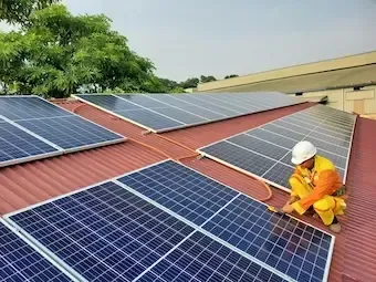 Technicien qui installe des panneaux solaires sur un toit