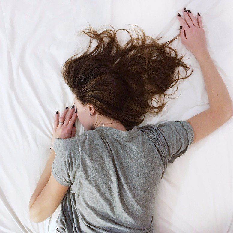 Woman lying face down in bed, illustrating exhaustion and lack of sleep support through Steady Sense.