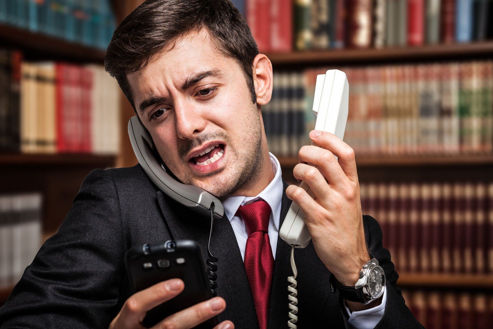 Stressed professional handling multiple phones, illustrating work-related stress through Steady Sense.