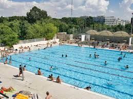 Desfibrilador en instalaciones de piscina, preparado para emergencias cardíacas y cumpliendo normativa de seguridad acuática