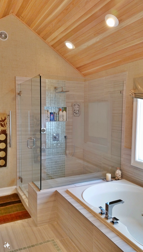 Renovated walk in shower by The Renovation Company with tiled seat, glass enclosure, and a glass tile waterfall effect running through a niche