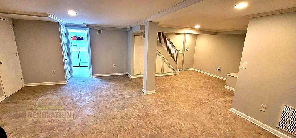 Remodeled basement by The Renovation Company with tiled floor, white base molding, gray walls, and recessed lighting