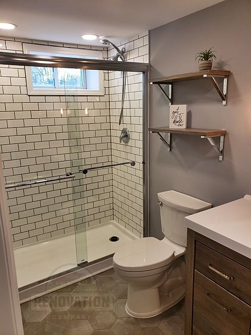 Full basement bathroom with white subway tile in the shower and black grout