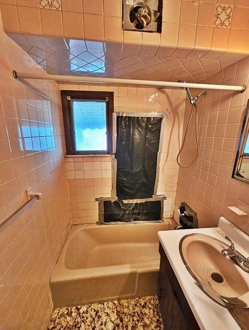 A pink bathroom in need of a renovation