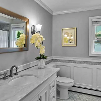 Renovated bathroom by The Renovation Company with wainscot walls and new fixtures