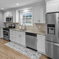 Remodeled kitchen by The Renovation Company with granite counters and stainless steel appliances