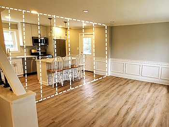 Renovated living room by The Renovation Company shows where a wall was removed