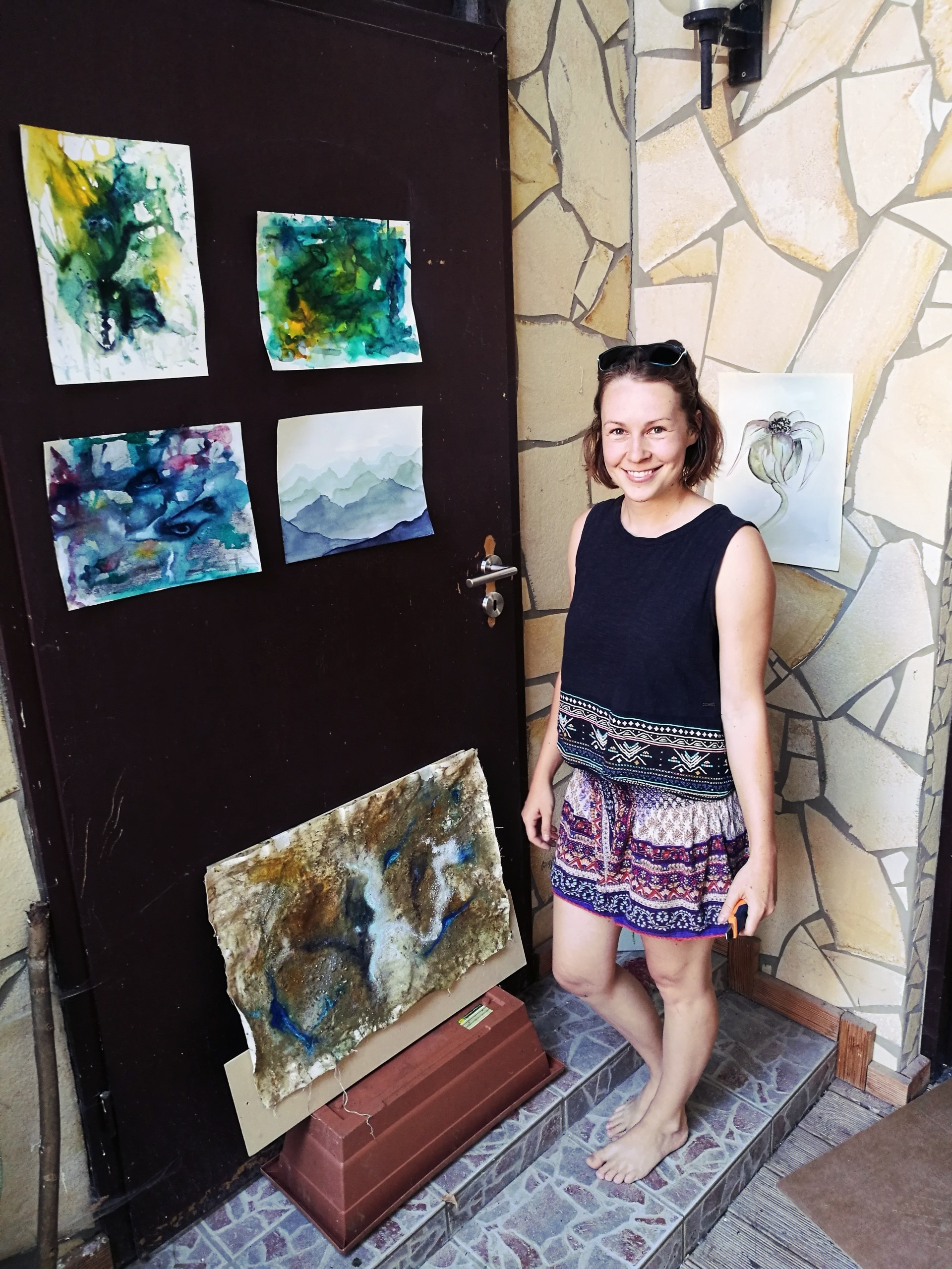 Rachel Alisa steht vor ihren Kunstwerken