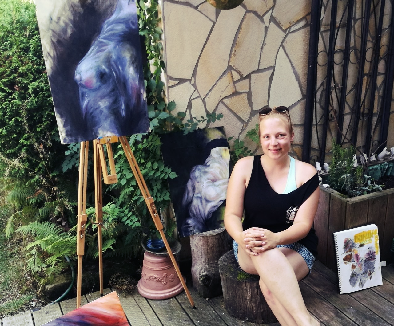 Liza Lechner sitzt vor ihren Kunstwerken