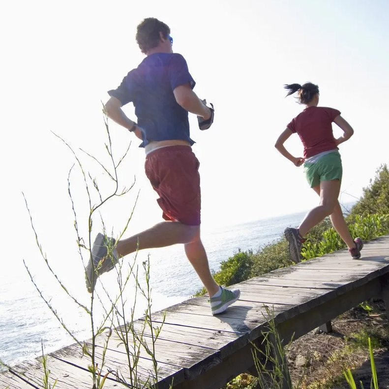 Personal Training Berlin, Potsdam, Oberhavel mit einem Paar, die zusammen in der Einheit joggen gehen und damit die schöne Natur Outdoor genießen.