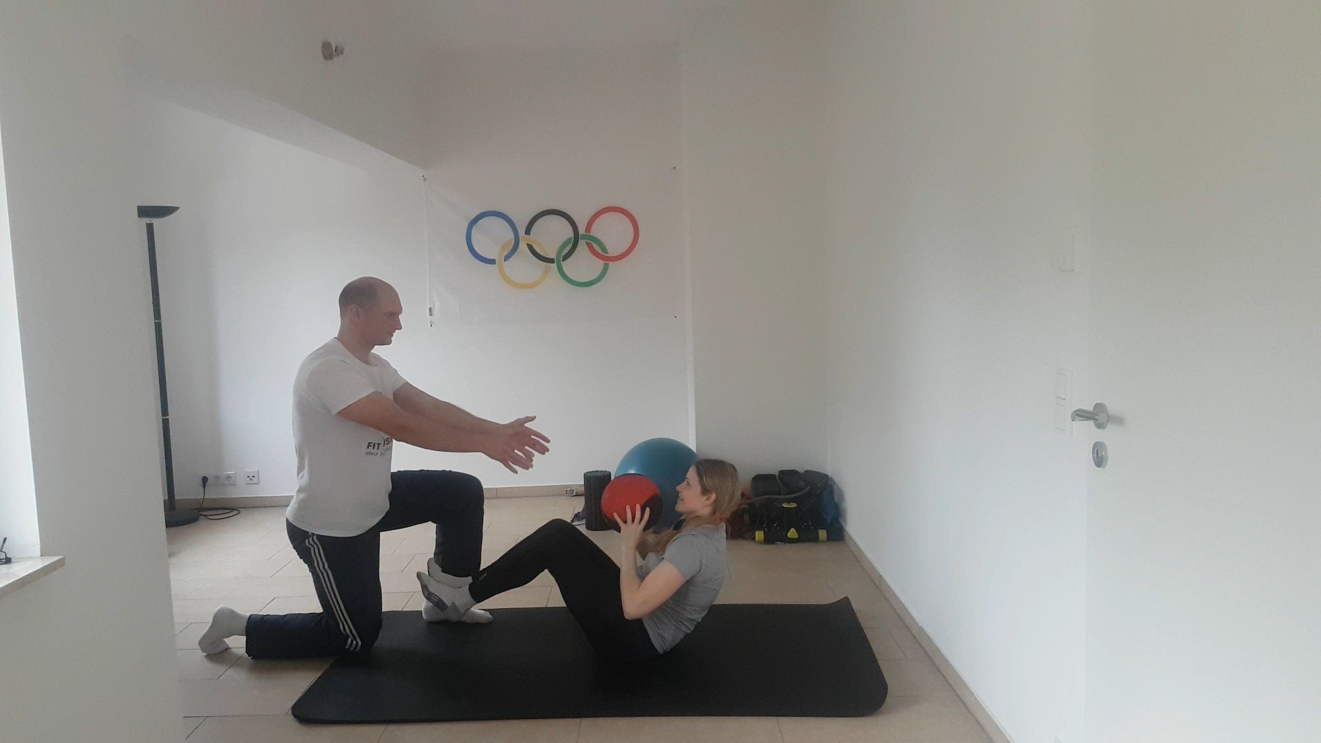 Personal Training Berlin, Potsdam und Oberhavel mit mir als Trainer Benjamin Müske beim Training mit einer Kundin beim Medizinballwurfübungen im liegen für die Bauchmuskeln und Arme