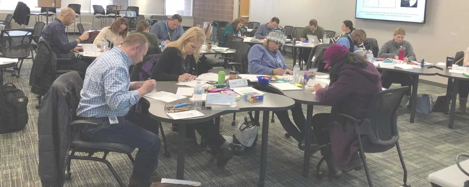 people in a conference room working at tables