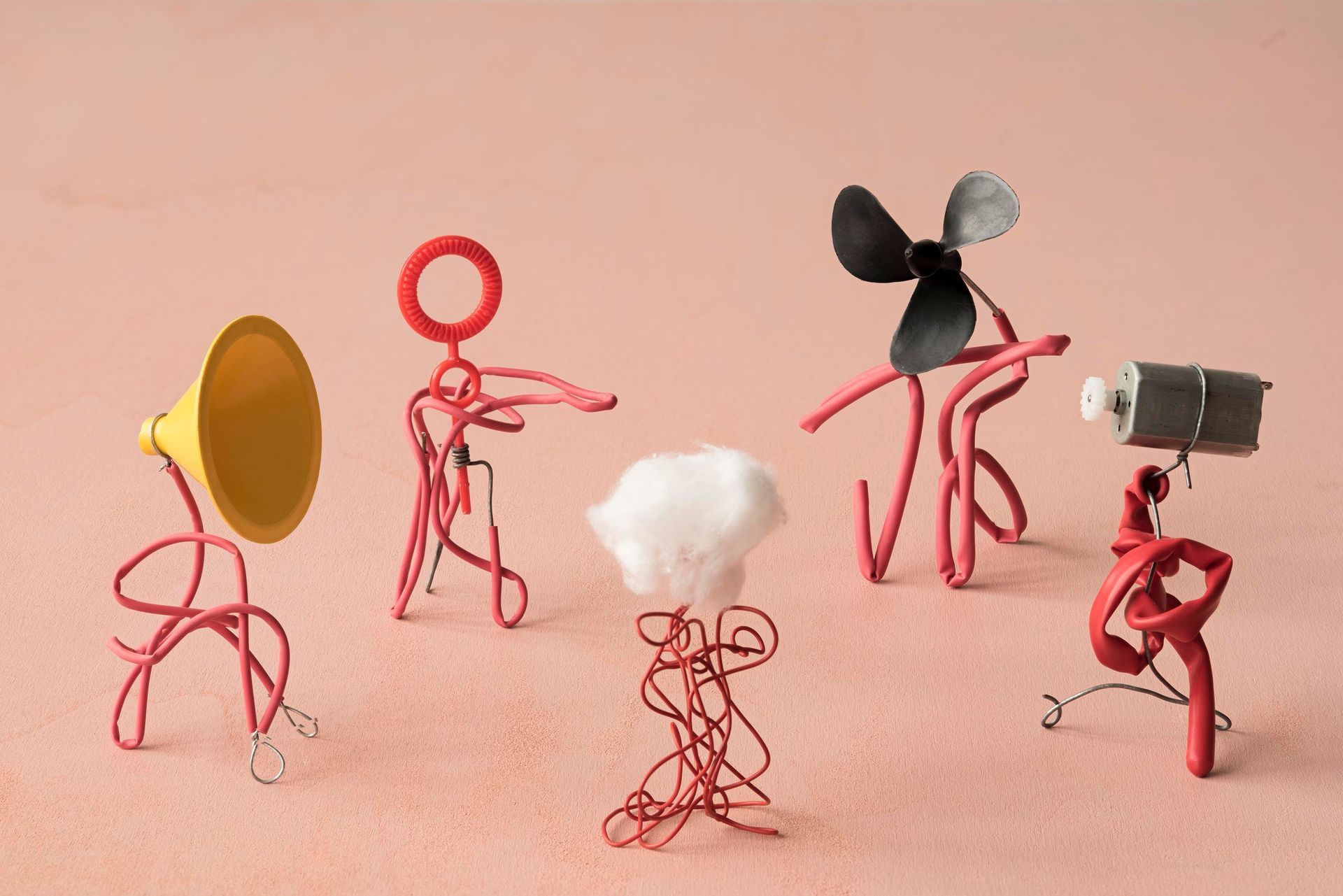 5 Drahtfiguren vor einem roten Hintergrund
