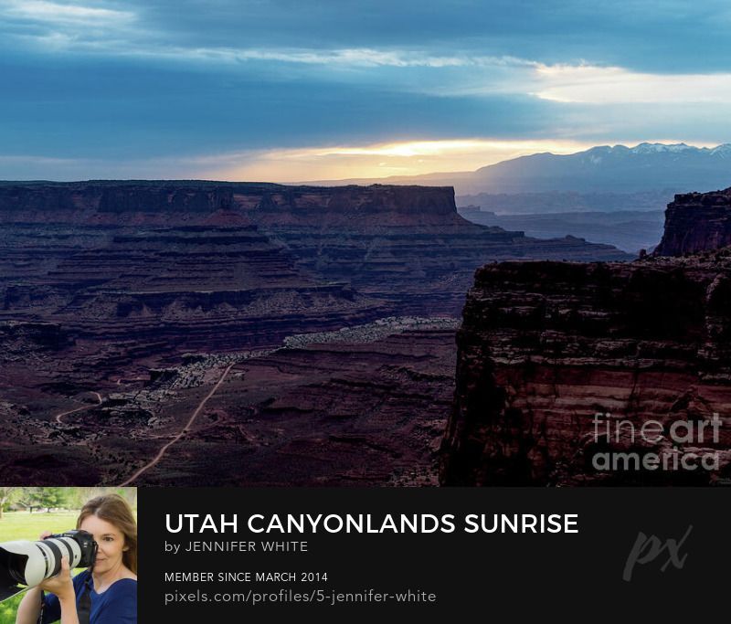 A hazy morning view looking towards the La Sal Mountains from the Shafer Trail switchbacks road overlook at Canyonlands National Park in Utah at sunrise by Jennifer White with Timeless Moments Photography.