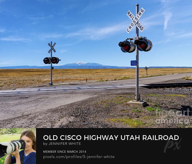 A desert landscape by a railroad crossing along Old Cisco Highway in  Utah with the La Sal Mountains in the background by Jennifer White with Timeless Moments Photography.