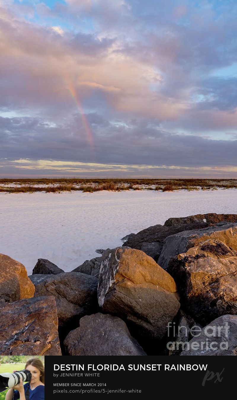 A fine art vertical photo of a rainbow during sunset in Destin, Florida by Jennifer White with Timeless Moments Photography.
