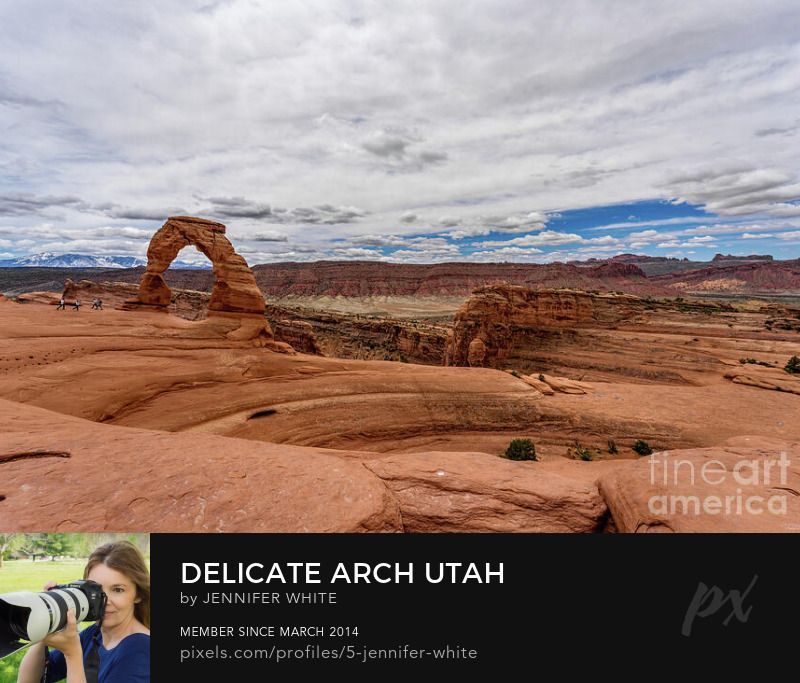 A wider view of Delicate Arch in Arches National Park in Moab, Utah, United States. You can see some people walking towards it to give you a perspective of it's size. This is the same arch you see on all the Ut