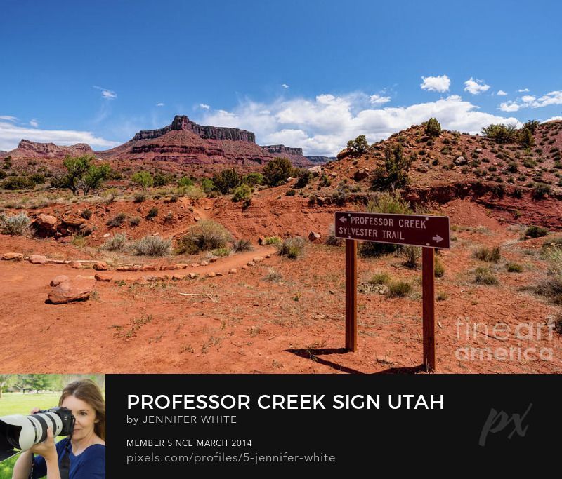 The sign at the start of the Professor Creek hiking trail in Moab, Utah with a view of the majestic Adobe Mesa mountains in the background.