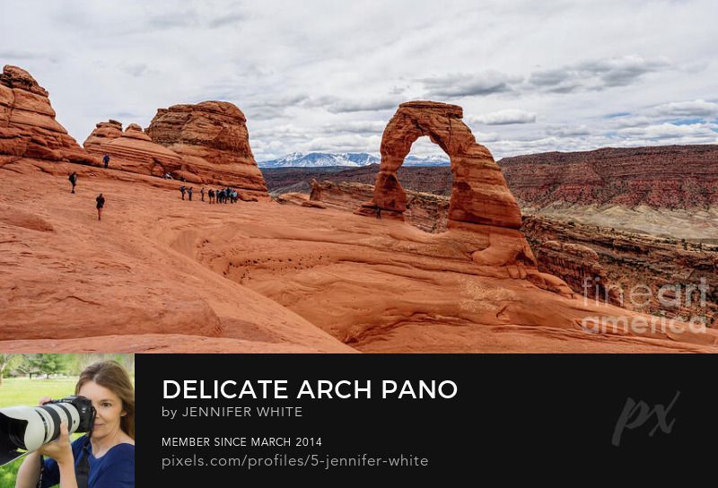 This view of Delicate Arch shows how steep the angle of the slick rock is down to the arch. You can see some people walking around and awaiting their turn for a photo under the iconic rock formation. 