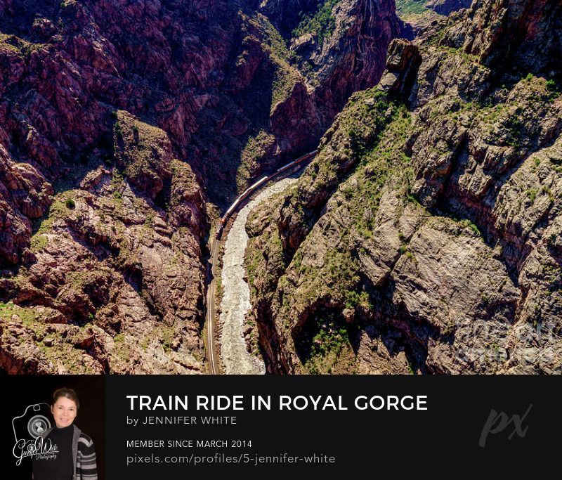 A view looking down into the Royal Gorge as a train rides by the Arkansas River. If you don't like heights, you do not want to walk across the Royal Gorge Bridge in Cañon City, Colorado