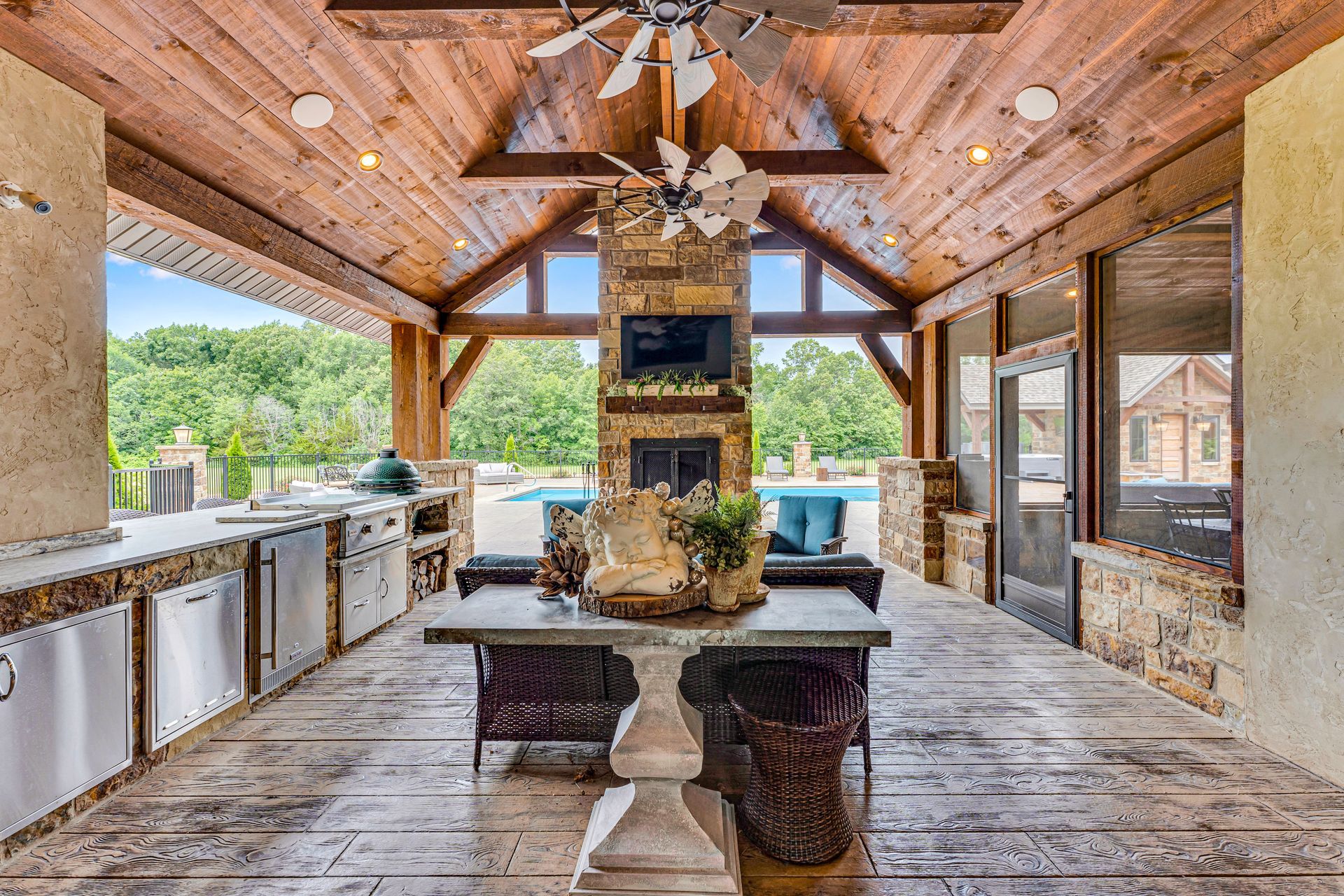 A photo of a covered patio entertainment area from a luxury home in Rogersville, Missouri. Professional photo by Jennifer White Timeless Moments Photography. Home built by Old World Cottages near Springfield Missouri.