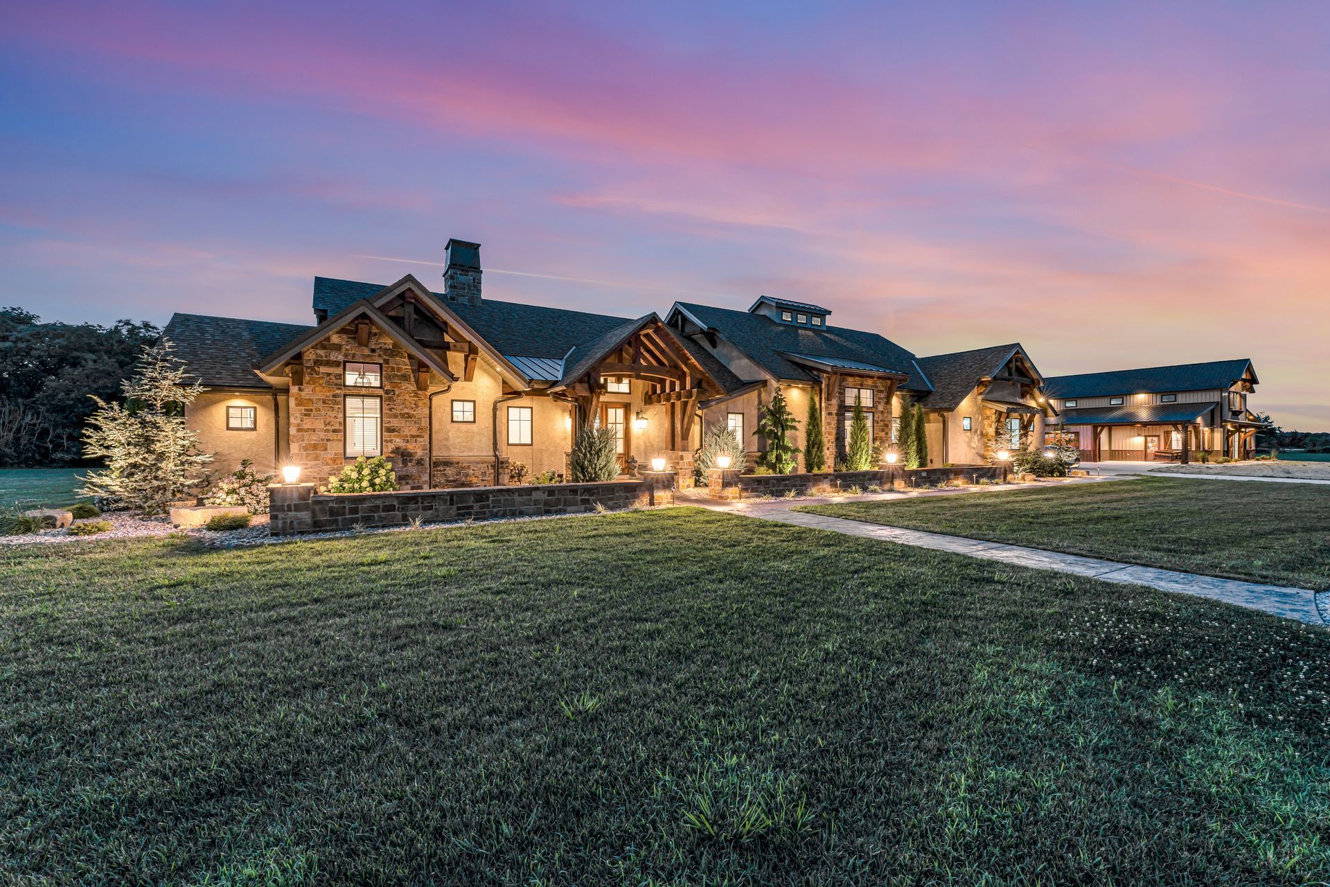 A dusk twilight exterior of the front of a luxury home in Rogersville, Missouri. Professional photo by Jennifer White Timeless Moments Photography. Home built by Old World Cottages near Springfield Missouri.