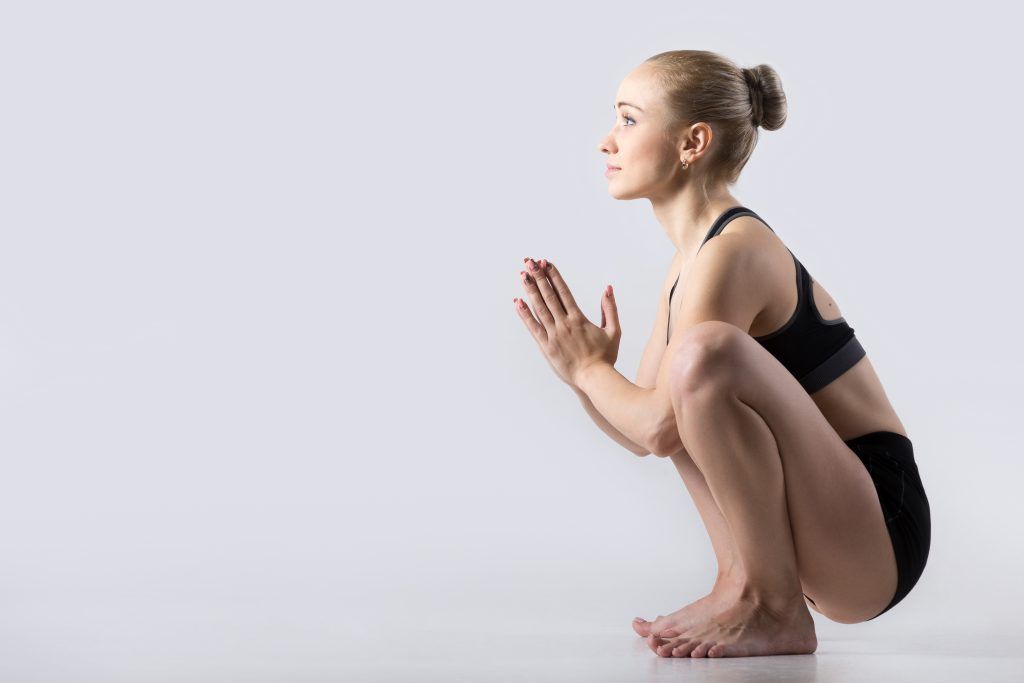 Mujer en posición malasana de yoga. Postura para mejorar la apertura de caderas y poder adoptar la posición ideal a la hora de defecar