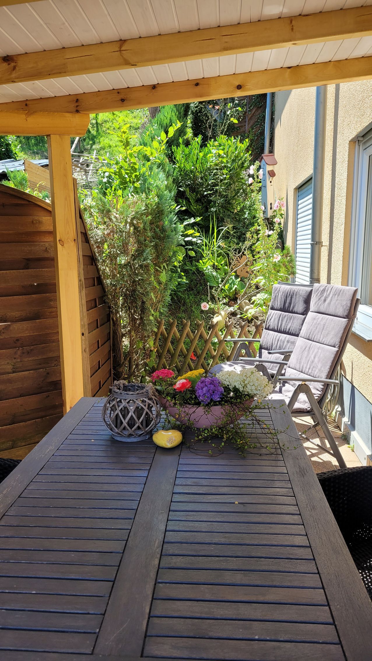 Terrasse mit Überdachung und Hanggarten
